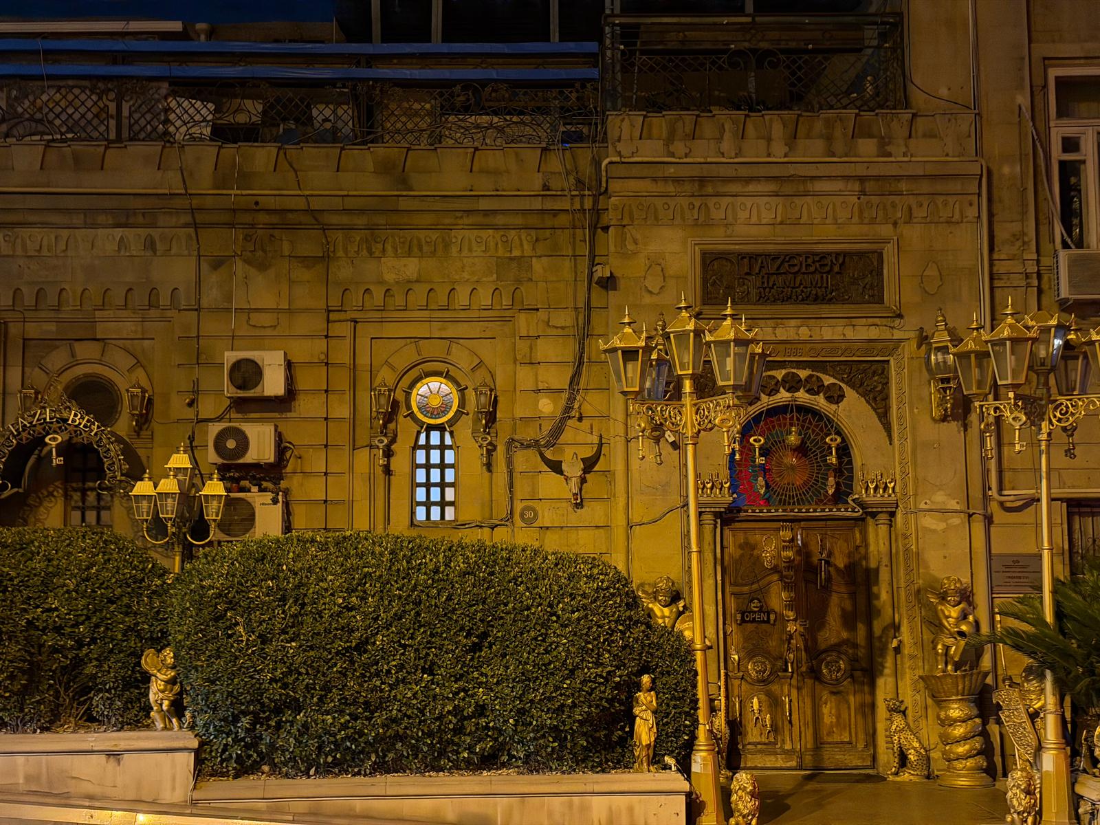 The ornate gilded entrance of the Taza Bey hammam in Baku at night