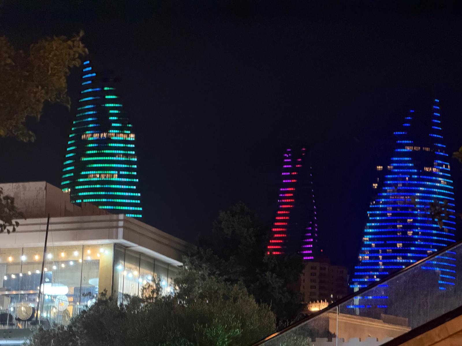 The three Flame Towers of Baku lit up at night in green, red, and blue