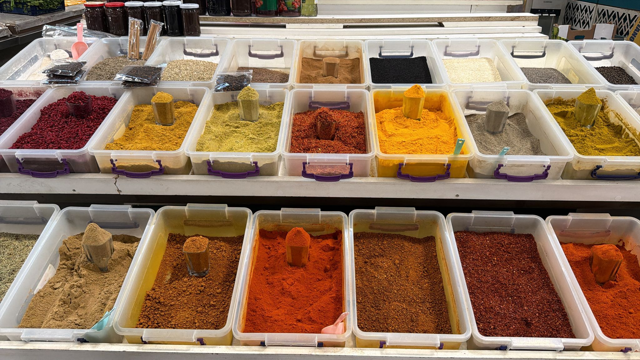 Open trays of spices — saffron, turmeric, sumac, dried barberries, paprika and blends — at a spice stall in Teze Bazar, Baku
Saffron, turmeric, sumac, barberry — the Silk Road sorted into trays, with cornelian cherry preserve behind.