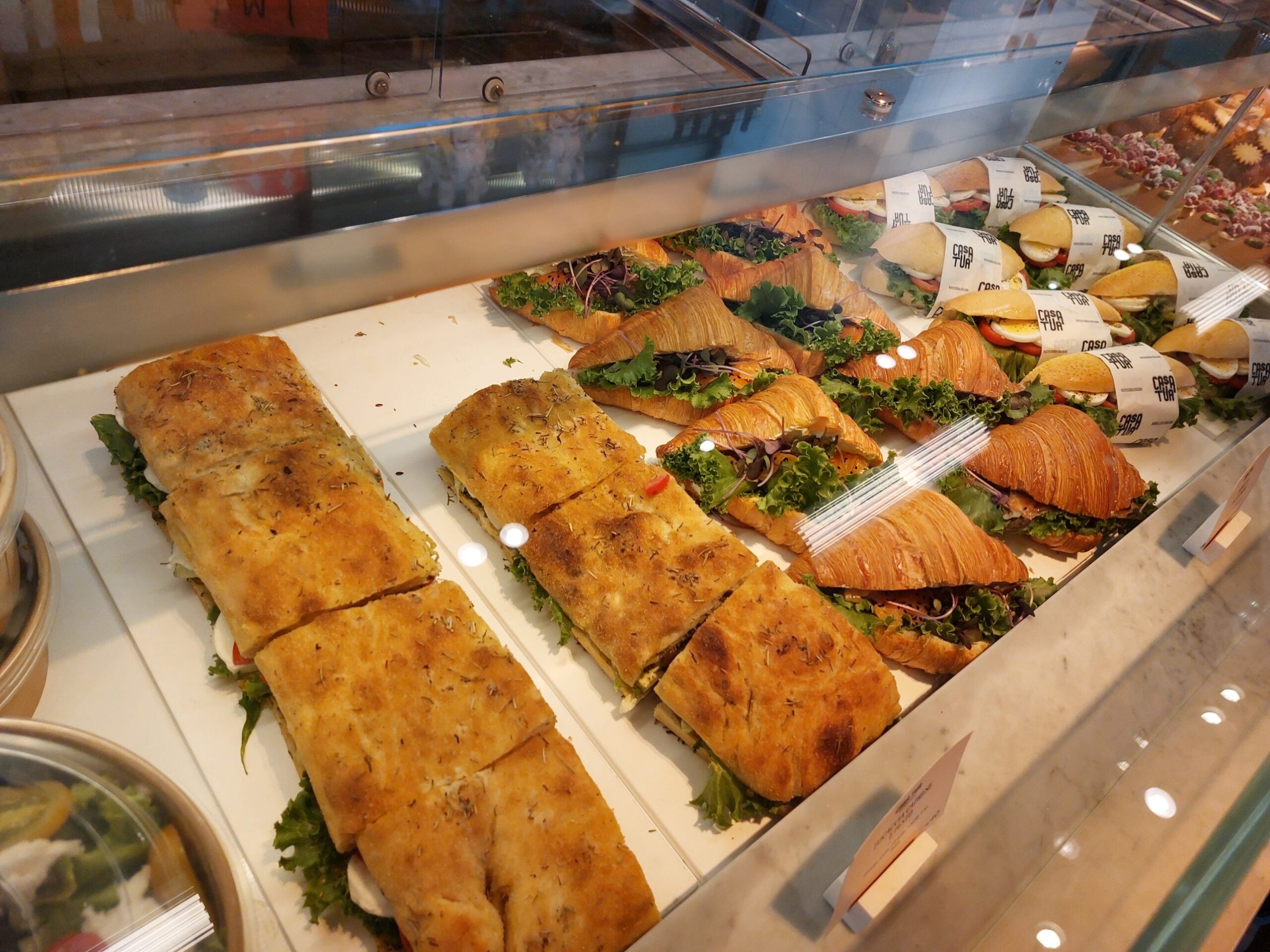 Rosemary focaccia sandwiches with mozzarella, croissant sandwiches with greens and wrapped panini in the Casa Tua savoury case